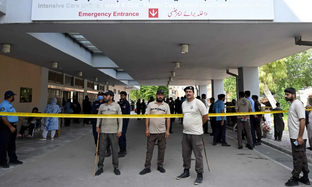 Security personnel stand guard outside the Mother and Child Health ward at PIMS Hospital in Islamabad following a deadly fire that killed 14 infants.