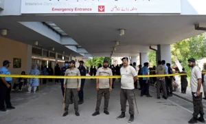 Security personnel stand guard outside the Mother and Child Health ward at PIMS Hospital in Islamabad following a deadly fire that killed 14 infants.